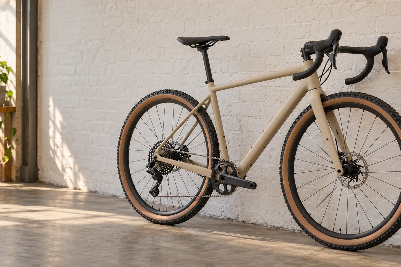 Illustration: ein neues sandfarbenes Gravelbike lehnt an einer weißen Ziegelwand im Laden